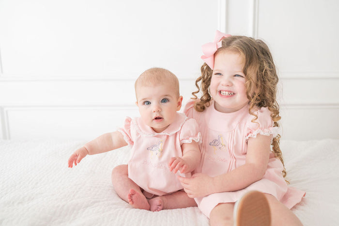 A little girl will feel so proud wearing this charming dress, featuring delicate stork embroidery and "Big Sister" lettering.