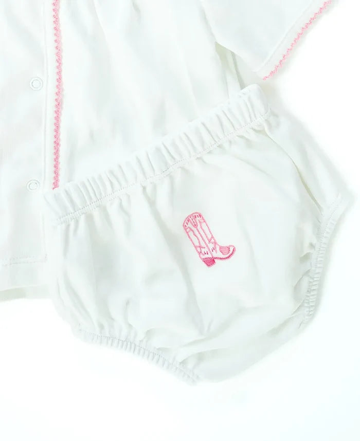 Close up of hand embroidery pink cowgirl boots on baby layette set.