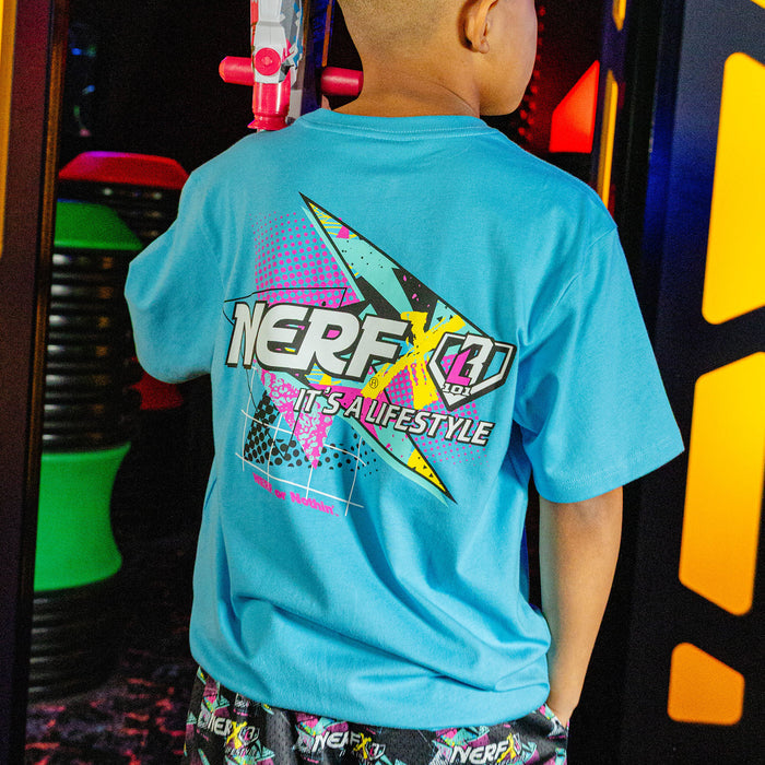 Child wearing a blue t-shirt with a 'NERF  X BL101' logo in an indoor play area
