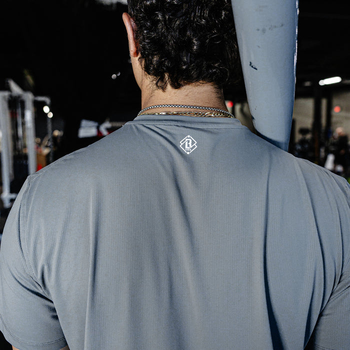 Person wearing a gray t-shirt with a logo on the back.
