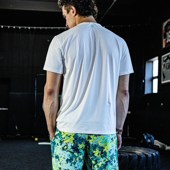 Person wearing a white t-shirt and colorful shorts in an indoor setting