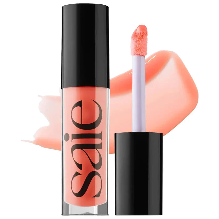 Saie Glossybounce™ high-shine hydrating lip gloss oil with a glossy finish, displayed in various shades on a splash background.