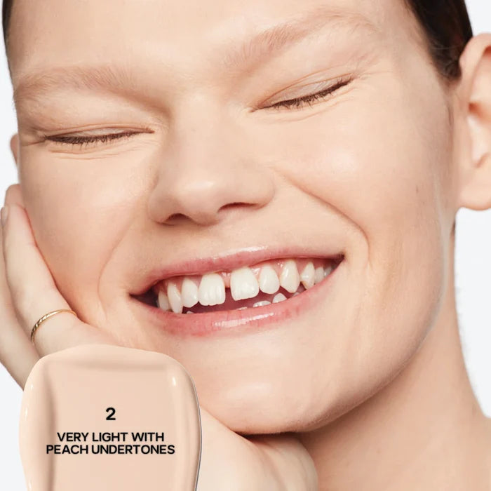 Saie Slip Tint Radiant All-Over Concealer in multiple shades, showing the sleek tube with a doe-foot applicator and product swatches.