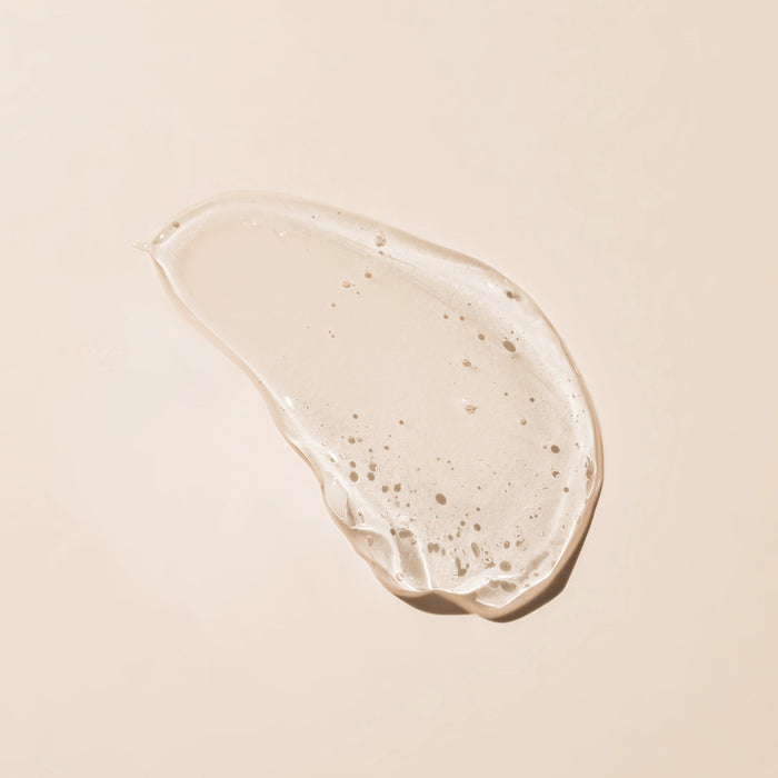 Luxurious skincare serum swatch with fine bubbles on soft beige background, showcasing lightweight texture for all skin types.