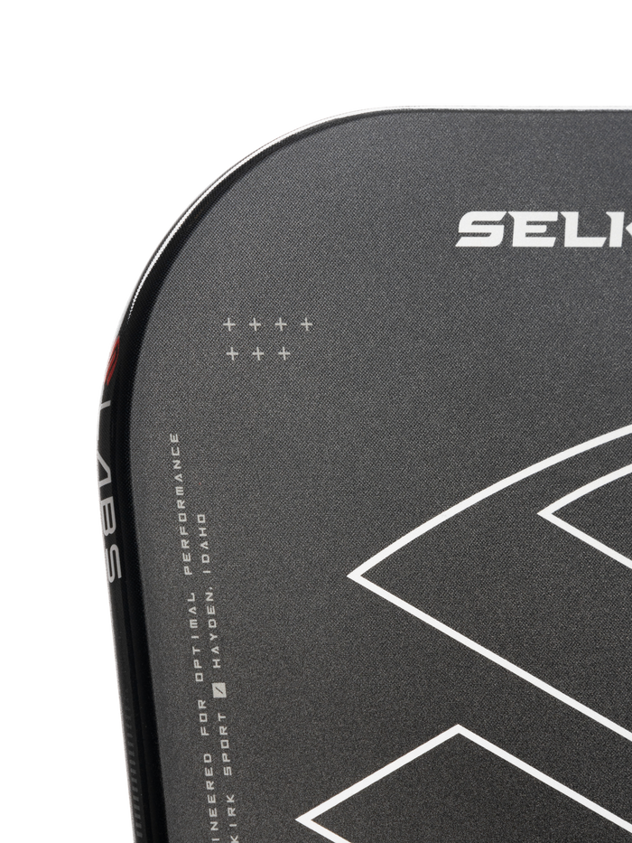 Corner of black paddle with SELK logo, white geometric design, vertical 'LABS', and text 'ENGINEERED FOR OPTIMAL PERFORMANCE HAYDEN, IDAHO'.