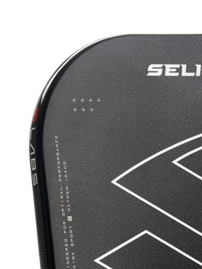 Close-up of a Selkirk paddle edge showing 'SELI' logo, 'LABS' on the rim and text 'ENGINEERED FOR OPTIMAL PERFORMANCE HAYDEN IDAHO'