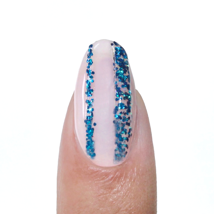 Shooting Stars liner used for a blue glitter vertical stripe on a sheer nude nail