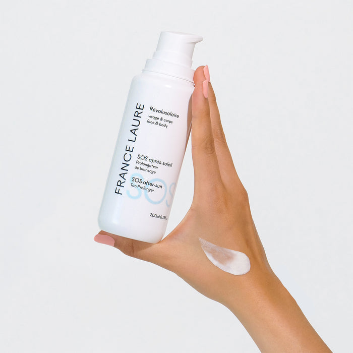 France Laure SOS after-sun tan prolonger lotion for face & body, shown with creamy texture swatch on hand