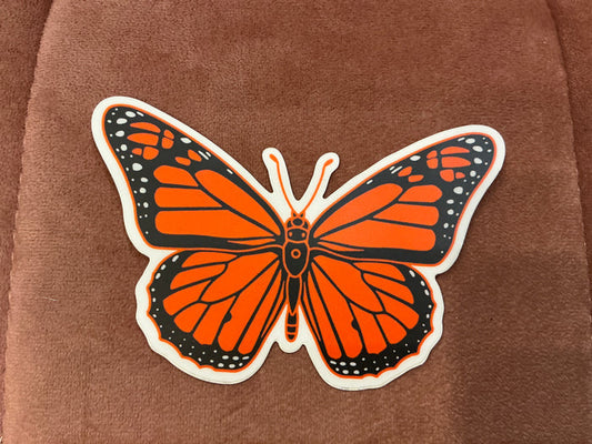 Colorful field guide designs monarch butterfly sticker with vibrant orange and black wings, ideal for decorating notebooks and laptops.