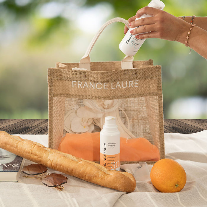 France Laure sun protection spray SPF 30 for face & body, shown with picnic essentials and a branded tote bag for outdoor skincare.