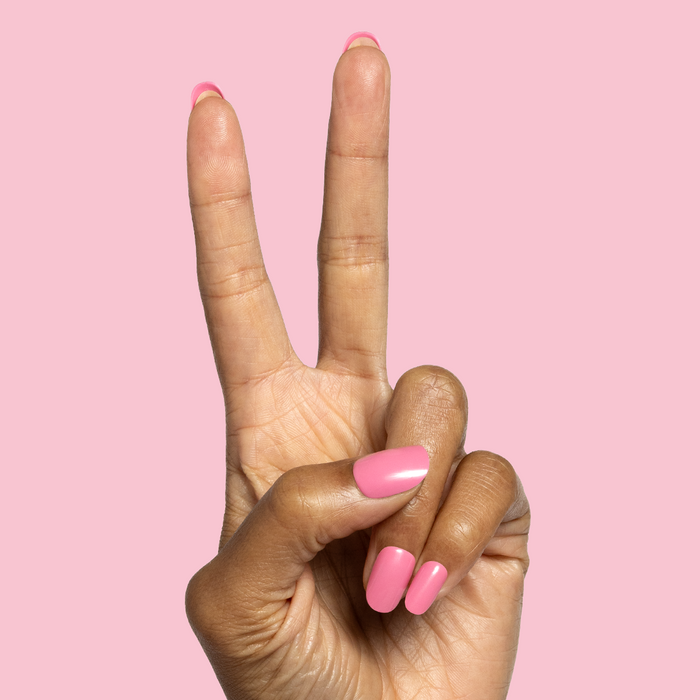Taffy | Short | Round - Tab Press-On showing glossy sugary sweet pink press-on nails on hand against soft pink background