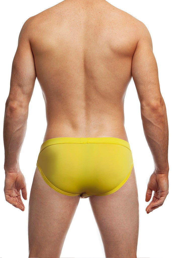 Man standing wearing a pair of Jack Adams Tanga Swim Brief (back view) on a white background.
