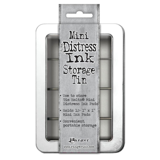 Tim Holtz - Mini Distress Ink Storage Tin - Holds 12. Ideal storage solution for mini distress ink pads! Organize and transport easily in a convenient clear windowed hinged tin. This package contains one 1x6.25x4.25 inch storage tin that will hold up to twelve mini inks. Imported. Available at Embellish Away in Bowmanville Ontario Canada..