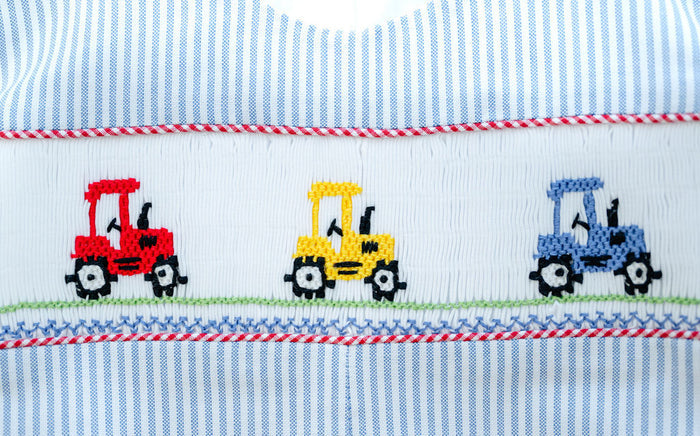 Close-up of smocked tractor embroidery detail on Ruth and Ralph blue striped Jon Jon