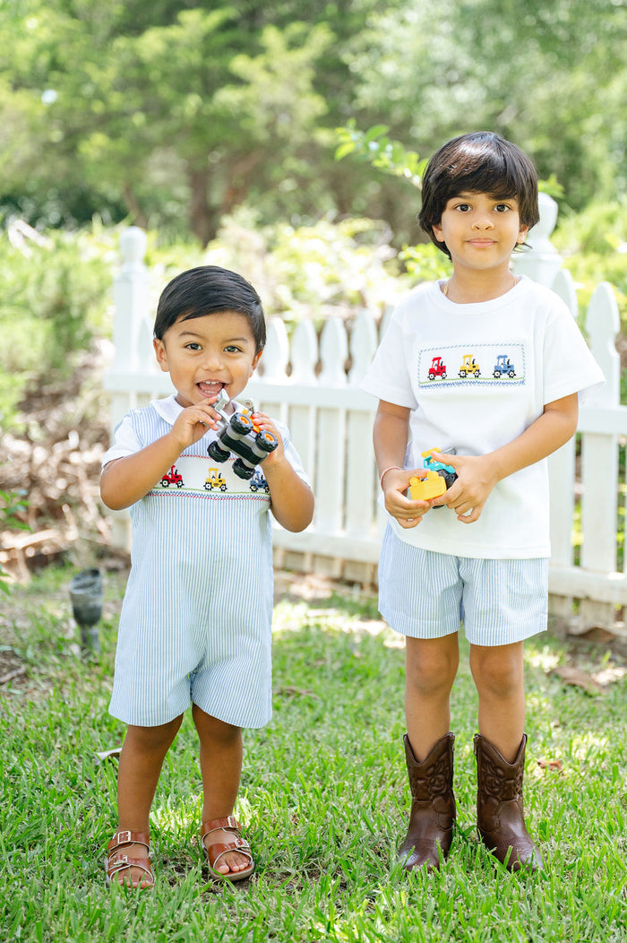 Close-up of two boys in matching Ruth and Ralph smocked tractor outfits, showing embroidered detail