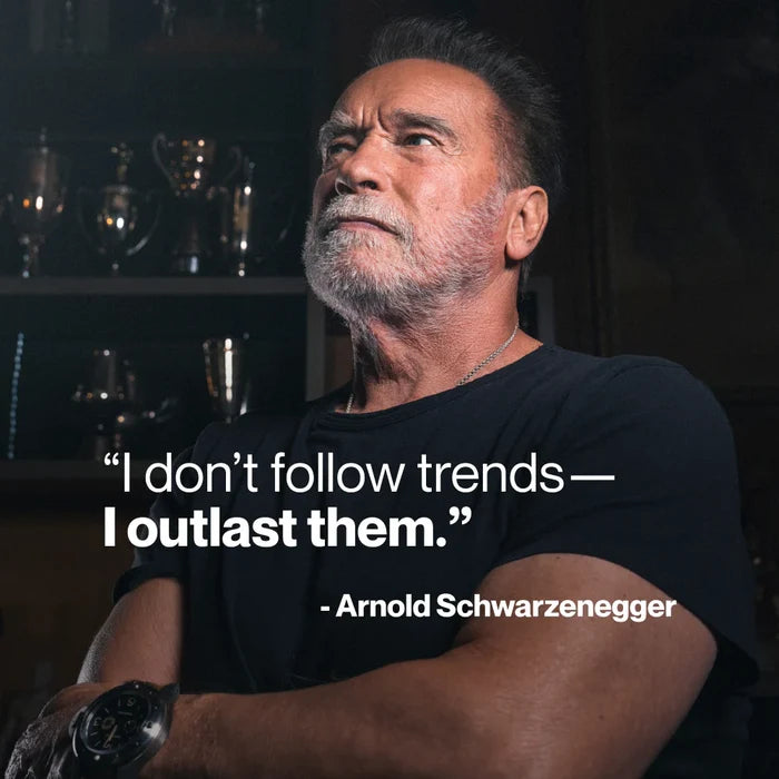 Portrait of Arnold Schwarzenegger seated with arms crossed, with quote: “I don’t follow trends—I outlast them.” — Arnold Schwarzenegger.