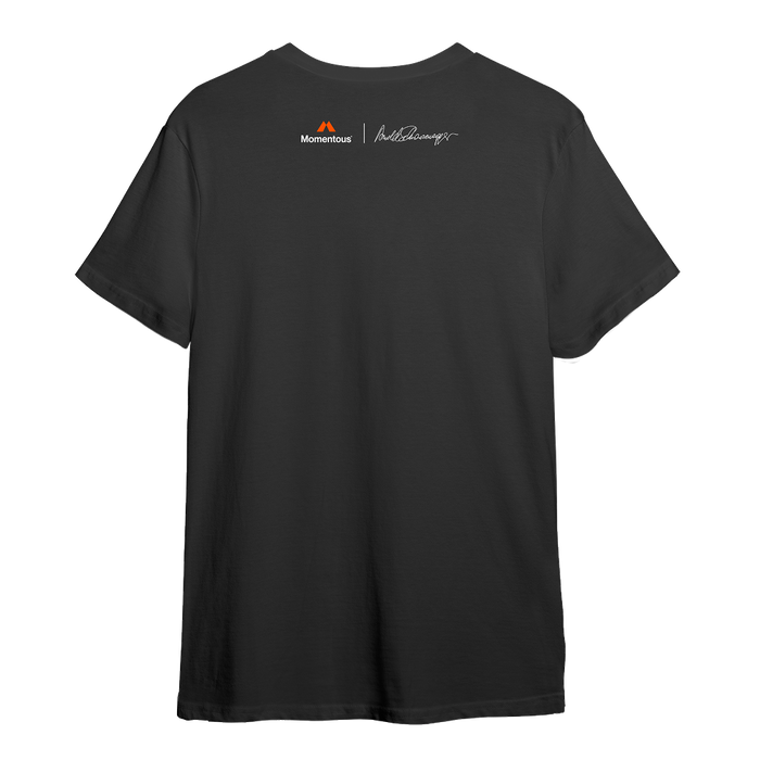 Back view of a charcoal gray athletic T-shirt with a clean, minimal design. Centered high across the upper back is a small orange Momentous logo and wordmark. To the right of it is a white signature graphic, referencing Arnold Schwarzenegger. The shirt has short sleeves and a straight hem, maintaining a sleek performance fit.