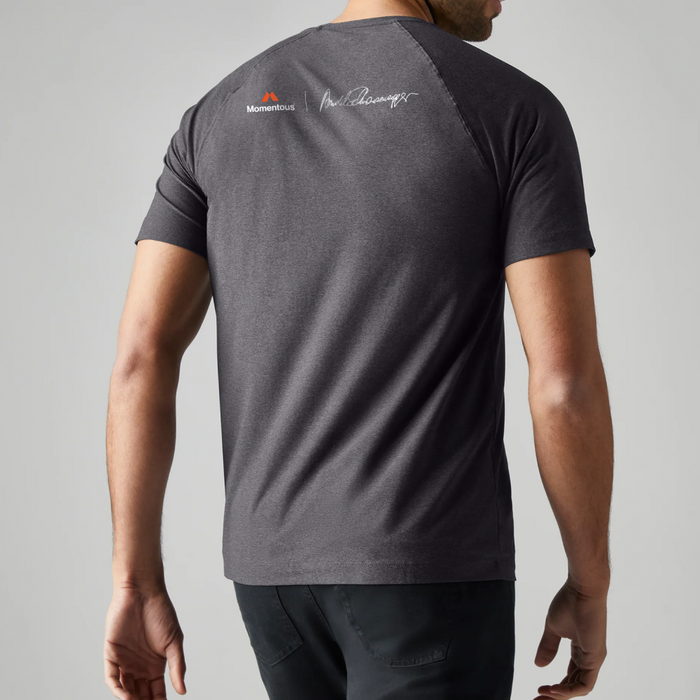 Back view of a gray athletic t-shirt featuring the orange Momentous logo and Arnold Schwarzenegger’s signature printed below the neckline.