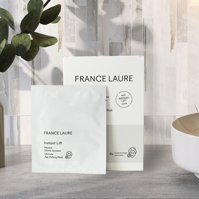 France Laure Instant Lift face mask packet and box, ultimate age-defying skincare for all skin types, displayed on bathroom counter with greenery